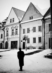 Rear view of man in house against sky