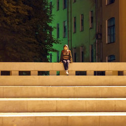 View of young woman sitting on concrete staircase