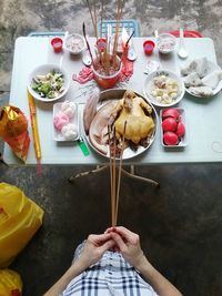 High angle view of women praying with religious offerings