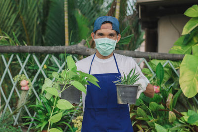 Portrait of man standing against plants