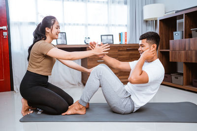 Side view of couple sitting on sofa at home