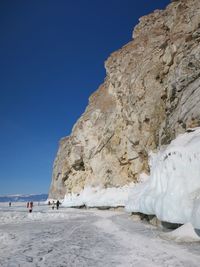 People by rock formation on snow