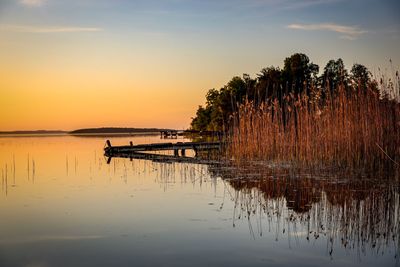 Scenic view of lake against sky at sunset