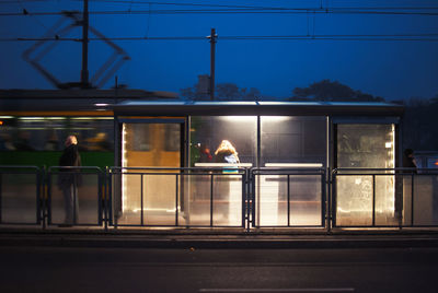 People traveling in illuminated tram at dusk