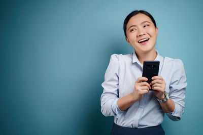Portrait of a smiling young man using smart phone