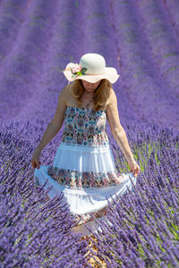 Woman standing amidst purple flowering plants