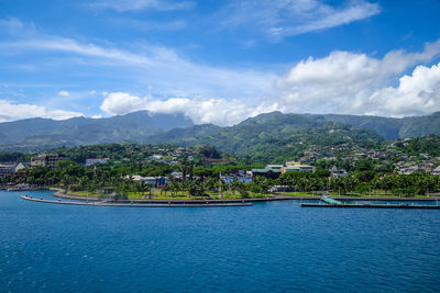 Scenic view of sea by buildings against sky