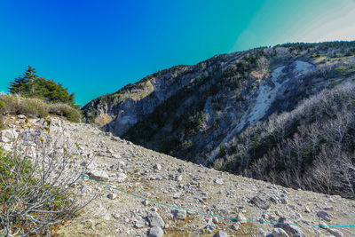 Low angle view of mountain against blue sky