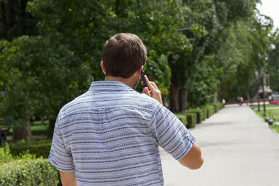 Rear view of man using mobile phone