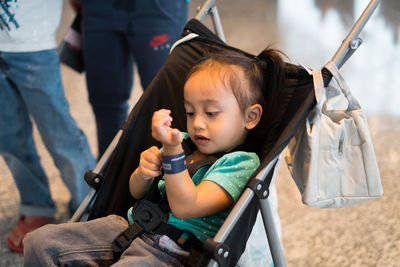 Cute girl sitting in baby carriage