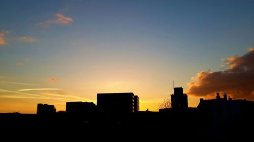 Silhouette buildings against sky during sunset