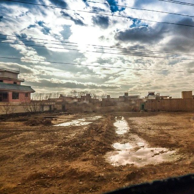 building exterior, architecture, built structure, sky, cloud - sky, cloud, cloudy, house, residential structure, water, city, weather, puddle, street, residential building, power line, day, outdoors, building, nature