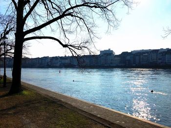 Scenic view of river by city against sky