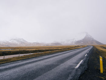 Empty road against sky during foggy weather