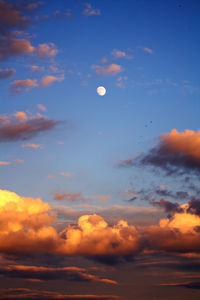 Low angle view of moon in sky at sunset