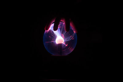 Close-up of illuminated lighting equipment against black background