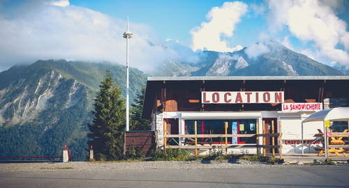 Road sign by street against mountains in city