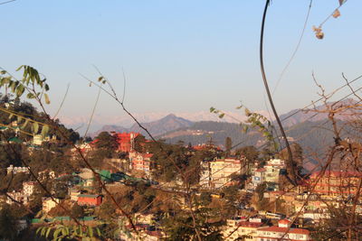 Aerial view of buildings in city against clear sky