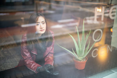 Woman looking at illuminated glass window