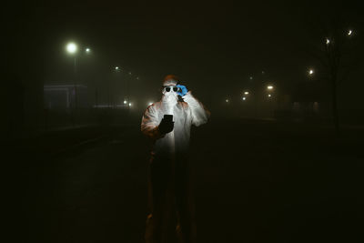 Man standing on street at night