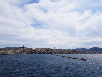 Scenic view of sea by buildings against sky