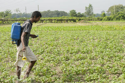 Farmer spraying fertilizer in agricultural field