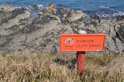 Close-up of warning sign on shore