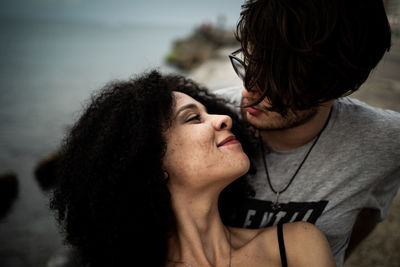 Portrait of couple kissing against sea