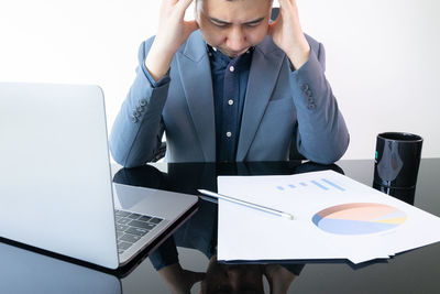 Low angle view of man using laptop on table