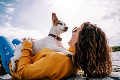 Smiling woman with floor against sky