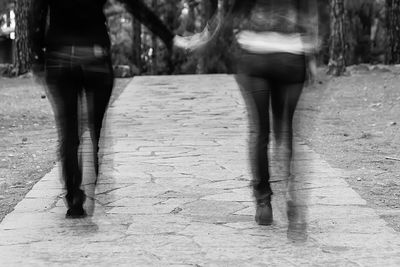 Low section of woman walking on road