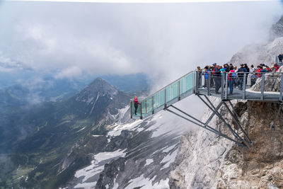 People on snowcapped mountains against sky