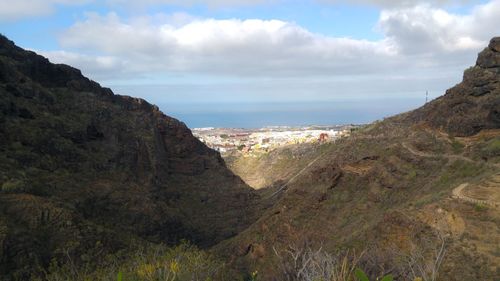 Scenic view of sea and mountains against sky