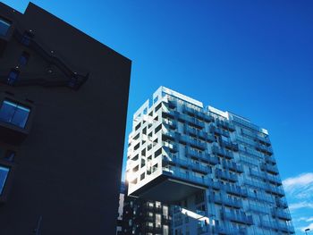 Low angle view of modern building against clear blue sky