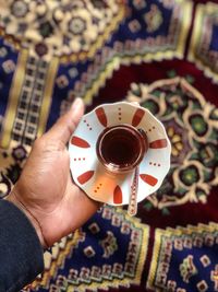 High angle view of hand holding coffee cup