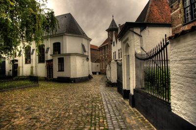 Street amidst houses and buildings against sky