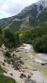 Scenic view of river by mountains against sky