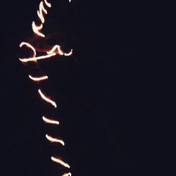 Close-up of lit candle against black background