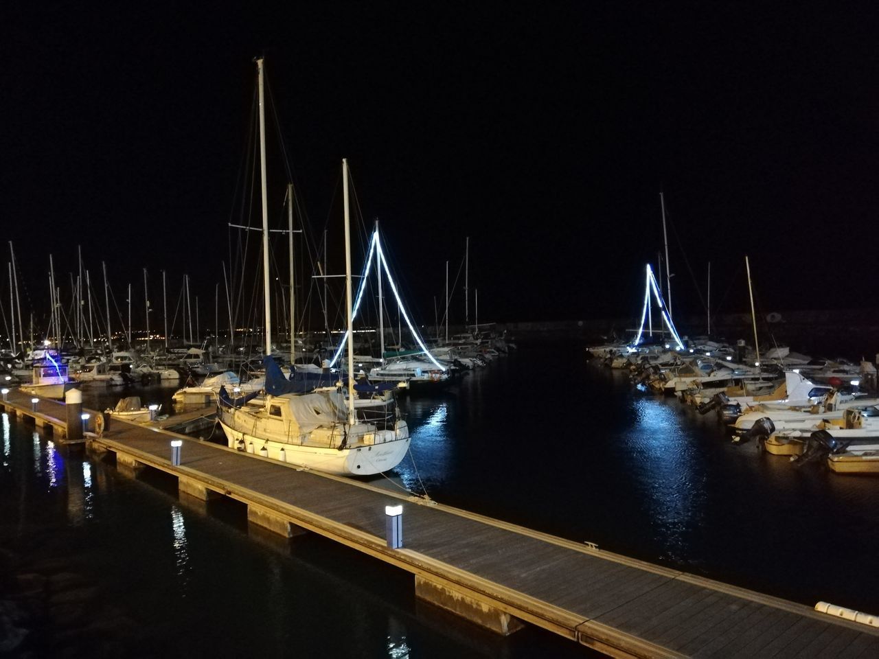 SAILBOATS MOORED AT HARBOR