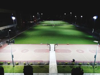 People playing soccer on field at night