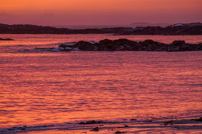 Scenic view of sea against orange sky