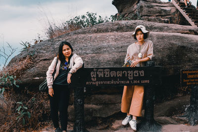 Portrait of young woman standing against graffiti