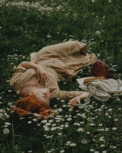 Red head woman laying on the grass in spring