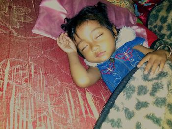 High angle view of cute girl sleeping on bed