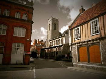 Buildings in city against cloudy sky