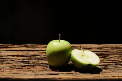 Close-up of apple on table against black background