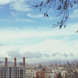 View of cityscape against cloudy sky