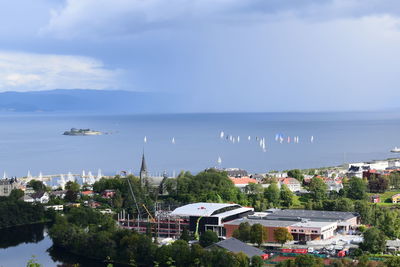 High angle view of buildings by sea against sky