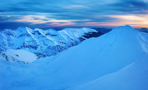 Scenic view of snowcapped mountains against sky during sunset