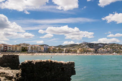 Buildings by sea against sky